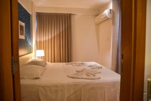 a hotel room with a bed with towels on it at Studio Moderno bem localizado in Feira de Santana