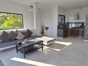 un salon avec un canapé et une table dans l'établissement Anankhira Villas, à Koh Tao