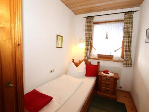 een klein bed in een kleine kamer met een raam bij Kirschbaum 3 in Ehrwald