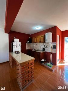 a kitchen with red walls and a counter in it at Apart Hotel Chilecito in Chilecito