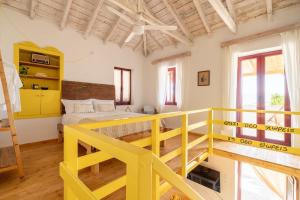 a large room with a yellow bed and a loft at Esperos petit house in Nerotriviá