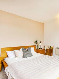 a bedroom with a large bed with white sheets at City Centre Rooms in Cardiff
