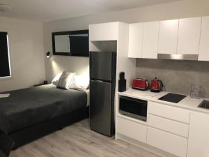 a small kitchen with a bed and a refrigerator at Foundry Apartments in Adamstown