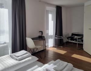 um quarto de hotel com uma cama, uma secretária e uma mesa em Am Basler Tor em Grenzach-Wyhlen