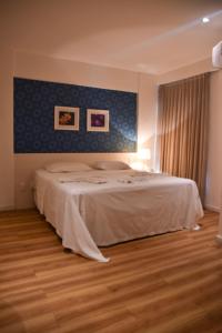 a bedroom with a large bed with a blue wall at Studio Moderno bem localizado in Feira de Santana
