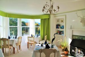 a living room with a table and chairs and a fireplace at Tirindrish House B&B in Spean Bridge
