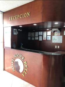 a reception area of a hotel with a sign at Hotel Noche Bella in Ipiales