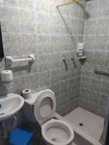 uma casa de banho com um WC e um lavatório em Hotel Noche Bella em Ipiales