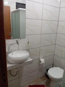 a bathroom with a sink and a toilet at Pousada Pontal da Armação in Penha