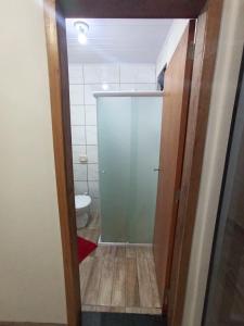 baño con puerta de cristal y aseo en Pousada Pontal da Armação, en Penha