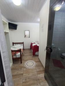Habitación pequeña con cama y baño. en Pousada Pontal da Armação, en Penha