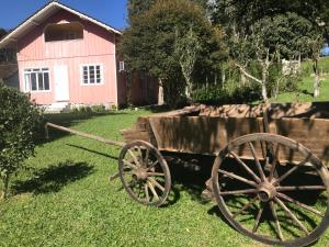 stary wóz przed czerwoną stodołą w obiekcie Gasthaus Heimat w mieście Rio Forcação