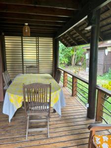 Great House BY Manaeva Lodge في Temae: طاولة وكراسي على سطح خشبي
