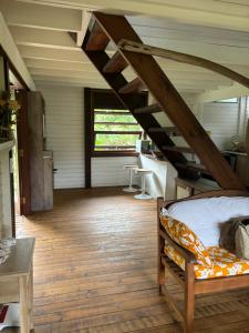 Schlafzimmer mit einem Bett und Holzboden in der Unterkunft Great House BY Manaeva Lodge in Temae