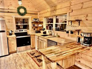 a wooden kitchen with a wooden table in a cabin at The Three Dog Night Cabin in Bryson City +15 photos