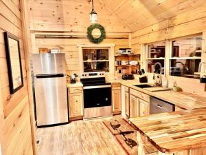 a kitchen with a stainless steel refrigerator in a cabin at The Three Dog Night Cabin in Bryson City