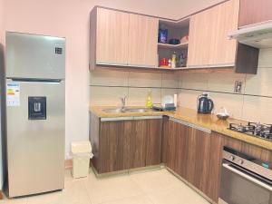 a kitchen with a refrigerator and a sink at 3-Bedroom Condo in a Golf Course in Santa Cruz de la Sierra