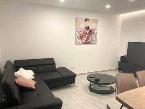 a living room with a black couch and a table at Family friendly house with a swimming pool Biograd na Moru, Biograd - 23272 in Biograd na Moru