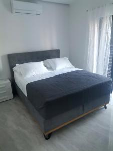 a bed in a white room with a black bedspread at Family friendly house with a swimming pool Biograd na Moru, Biograd - 23272 in Biograd na Moru +16 photos