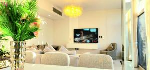 a living room with a couch and a tv at Gharfar Verdant Retreat 3Bedroom Villa in Dubai