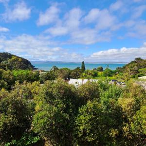 a view of the ocean from a hill with trees at Whatuwhiwhi TOP 10 Holiday Park in Tokerau Beach