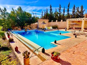 ein großer Pool mit blauem Wasser im Hof in der Unterkunft QUIET OASIS Luxury Stone Villa with Panoramic Views near Essaouira in Essaouira