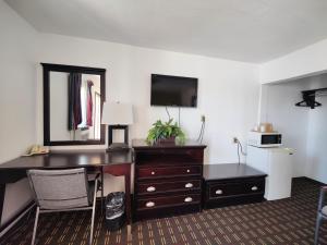 a hotel room with a desk and a mirror at Desert Inn in Van Horn