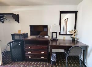 a desk with a computer and a mirror in a room at Desert Inn in Van Horn