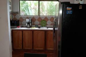 a kitchen with a refrigerator and a sink and a window at Casa Bonilla El Tirol Heredia CR in Alto del Roble +13 photos
