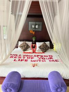 a bed with two purple chairs in a bedroom at Private Pool Classic Villa in Kuta