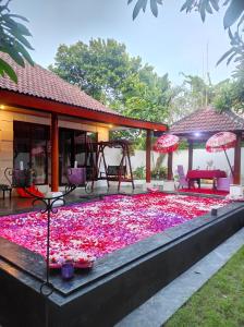 a large pool of pink flower petals in front of a house at Private Pool Classic Villa in Kuta
