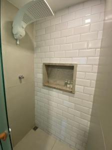 a bathroom with a white tiled wall with a window at Casa na Árvore in Salvador