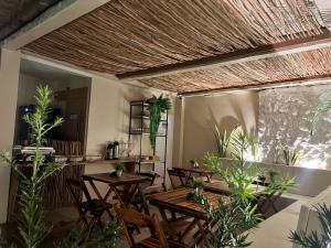 un restaurante con mesas de madera, sillas y plantas en Edifício Creta, en São Luís
