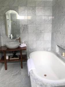 a white bathroom with a tub and a sink at Fairbank House in Maldon