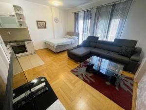 uma sala de estar com um sofá e uma mesa em Renta Stanovi Podgorica em Podgorica
