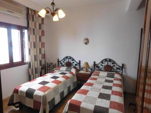 two beds sitting next to each other in a room at Appartement moderne à 5 min de la plage in Cabo Negro