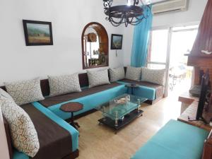 a living room with a couch and a table at Appartement moderne à 5 min de la plage in Cabo Negro