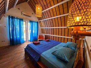 a bedroom with a bed with blue sheets and a lamp at Coconut Dream Villas in Gili Trawangan +89 photos