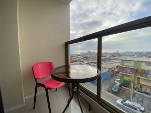 una mesa y una silla en una habitación con ventana en Hostal Quinta Normal en Antofagasta