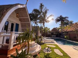 a house with a swimming pool next to a house at Coconut Dream Villas in Gili Trawangan