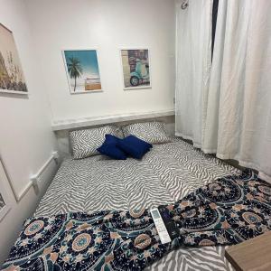 uma cama com almofadas azuis num pequeno quarto em Residencial Napolitan em Manaus
