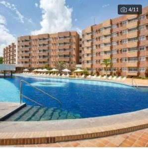 a large swimming pool in front of a building at Gran lençóis Flat Residence in Barreirinhas