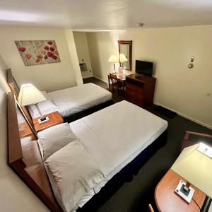 a hotel room with two beds and a desk at North Colony Motel and Cottages in Bartlett