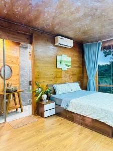 a bedroom with a bed and a wooden wall at 6Senses Garden Homestay in Hòa Bình