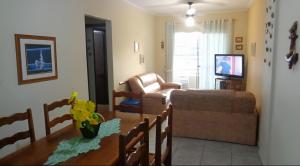 a living room with a couch and a table at Acolhedor com suíte e wi-fi in Praia Grande