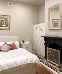 a bedroom with a bed with a fireplace and a mirror at Fairbank House in Maldon