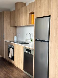 a kitchen with a stainless steel refrigerator and a sink at Rooftop Residence in Auckland