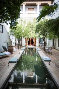 a pool in the courtyard of a house at Riad Le Rihani in Marrakesh