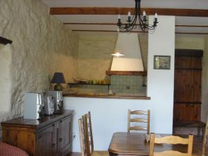 a dining room with a table and a kitchen at Les Gîtes De La Chérine in Quinson