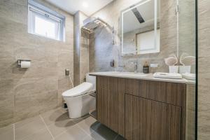 bagno con servizi igienici, lavandino e specchio di Haeilri Pool&SPA Hotel a Seogwipo